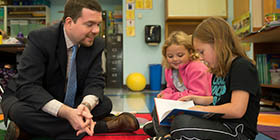 Teacher on the floor with young students